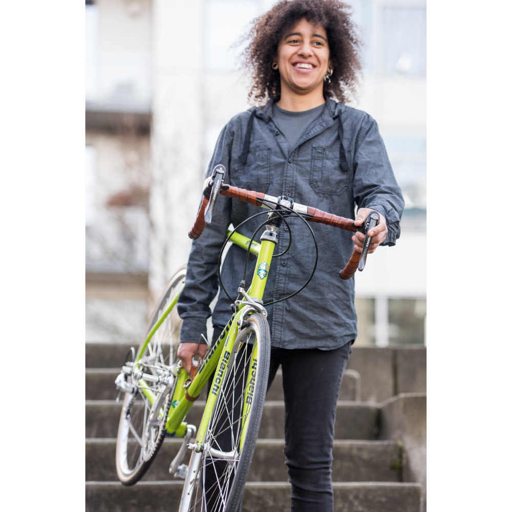 Person carrying green bike downstairs using the &quot;little lifter&quot; leather bike handle