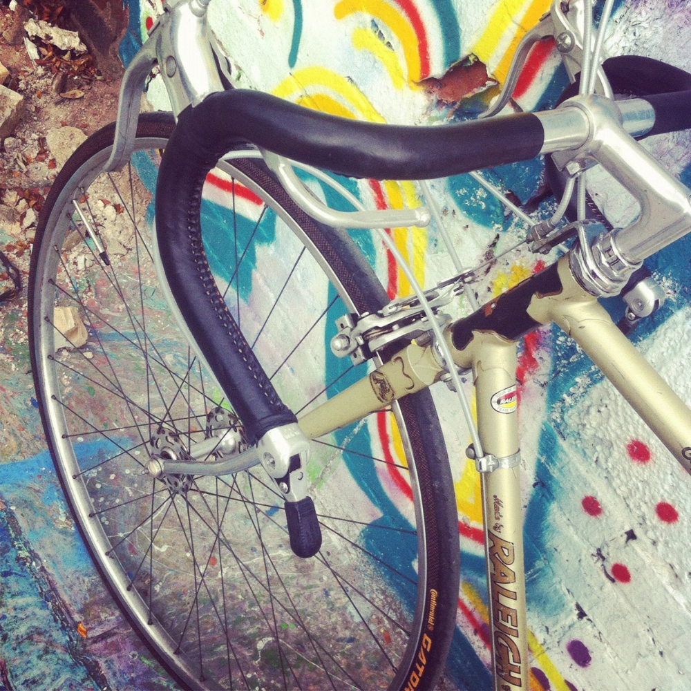 Customer photo from Switzerland. Black sew-on leather bar wraps on a standard drop bar handlebar on a vintage steel Raleigh bicycle frame. 